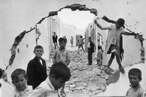 henri-cartier-bresson-hyeres-france-1932-seville-spain-1944-wall-hole-children-playing